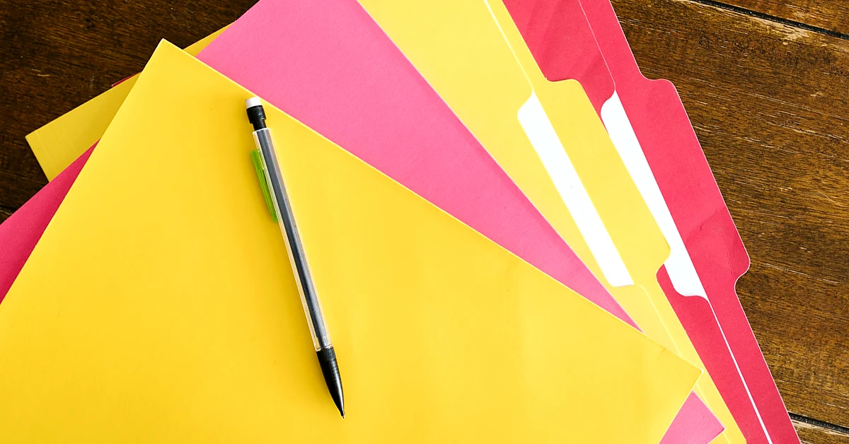Colorful document folders and a pen arranged on a wooden desk, illustrating the organization of related affiliate blog topics.