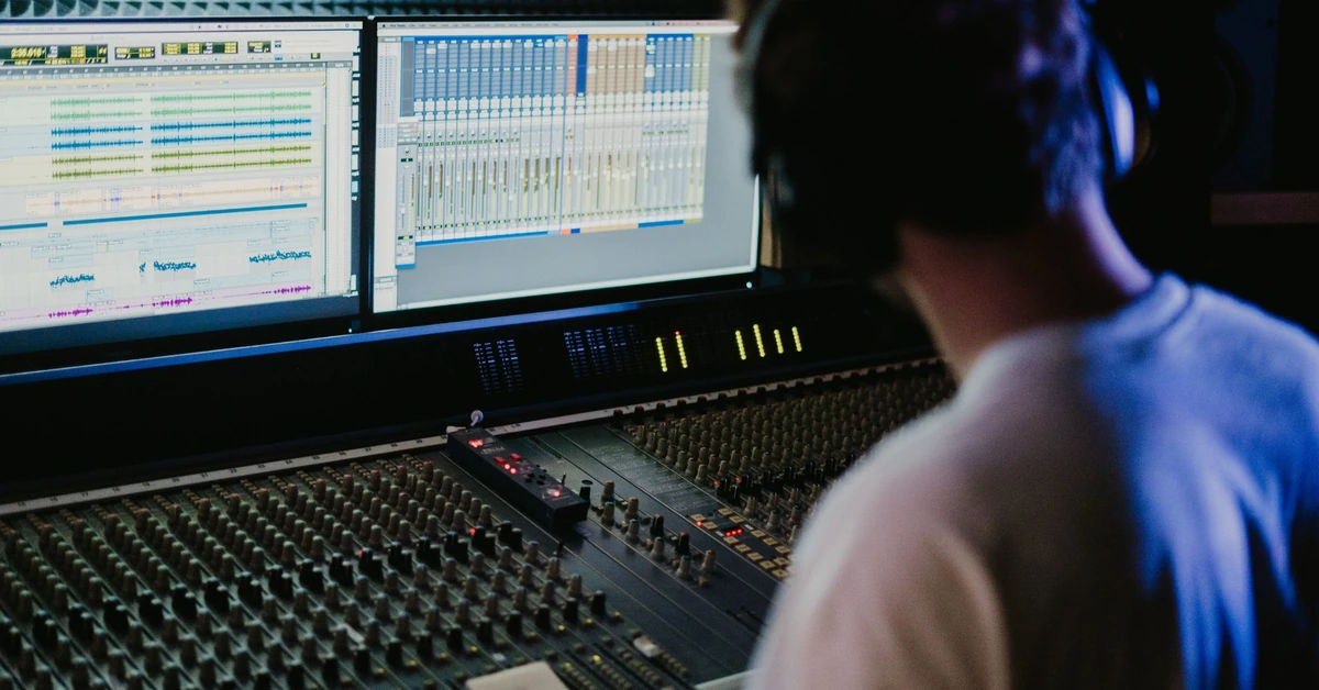 Sound engineer adjusting individual controls on a mixing console, illustrating why marketers should test one meaningful change at a time when improving subscriber conversions.