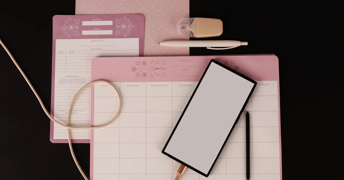 Organized planner, tablet, pen, and stationery arranged on a desk, illustrating the value of documenting clear affiliate campaign naming rules.
