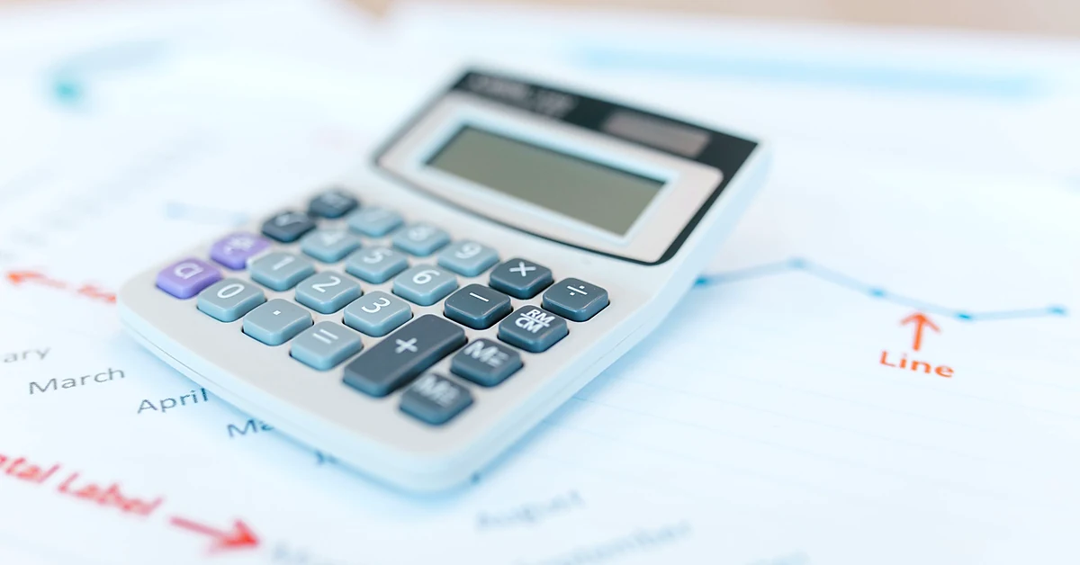 Calculator resting on financial charts and documents while evaluating changes to affiliate commission payouts.