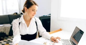 Professional woman reviewing financial reports beside a laptop while evaluating affiliate commission rate changes.