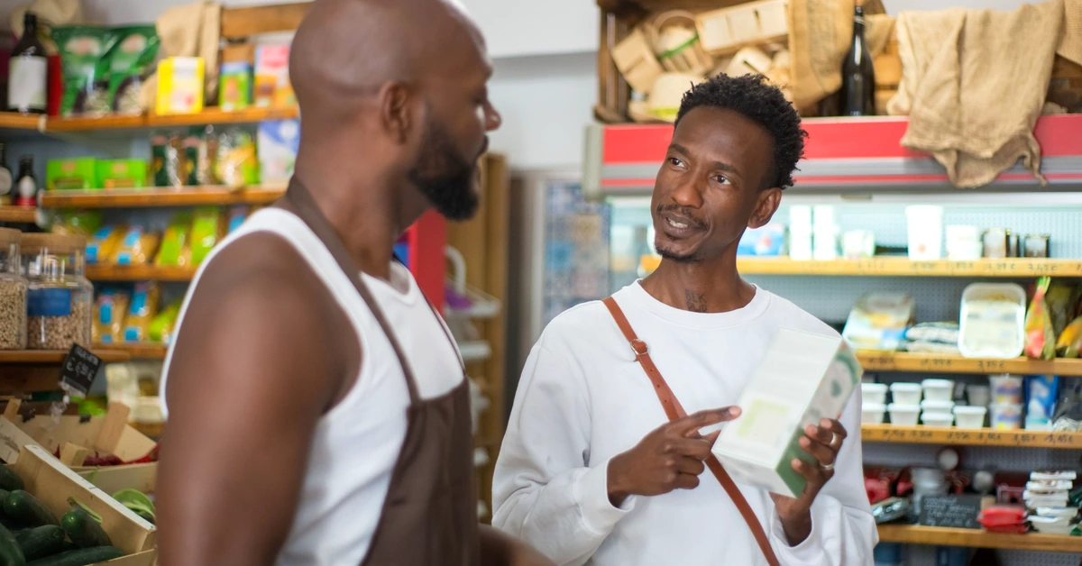 Customer and shop owner discussing a product together, representing careful comparison and an informed buying decision