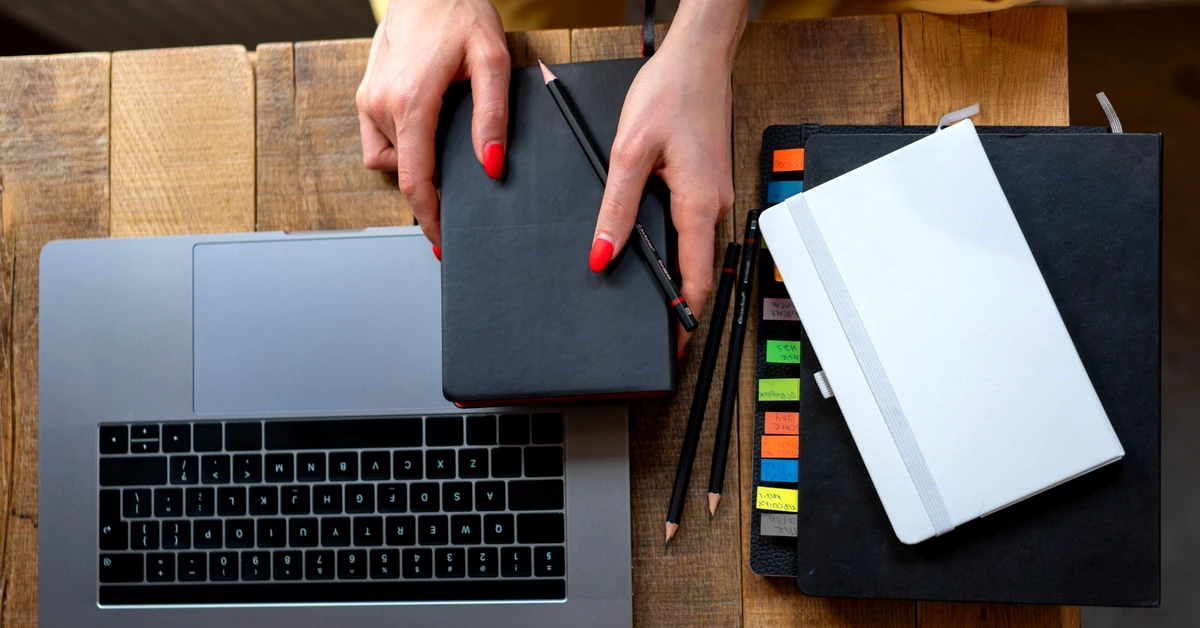 Content planner organizing notebooks and a laptop while structuring ideas for an affiliate article