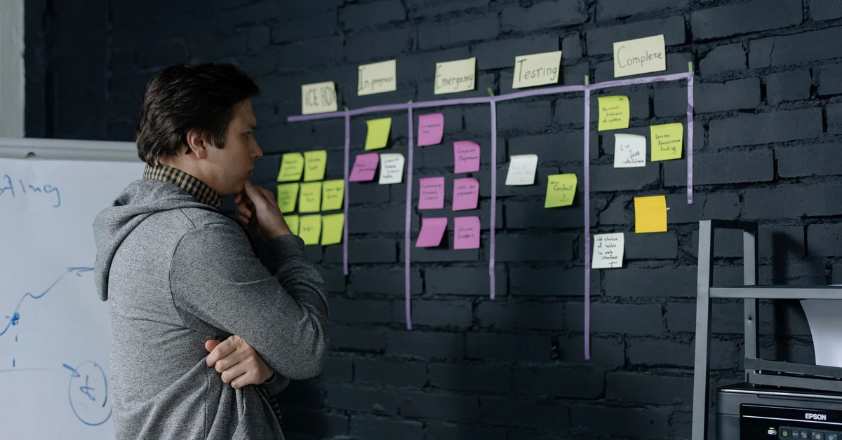 Man reviewing sticky notes on a planning wall while organizing affiliate blog content topics.