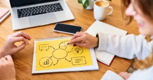Two people collaborating at a desk while organizing a visual content planning diagram for an affiliate marketing strategy