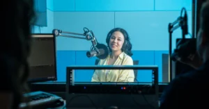 Podcast host speaking into a studio microphone, illustrating a timely broadcast sent directly to an audience.