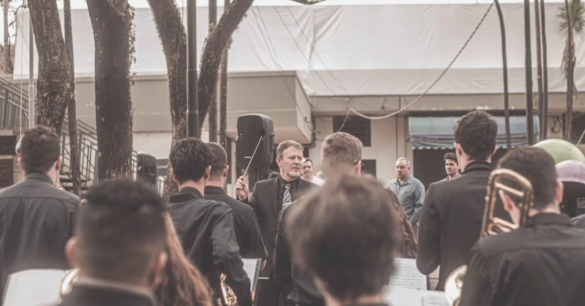 Orchestra conductor directing musicians, illustrating the need to coordinate automated emails and broadcasts so messages do not overlap.