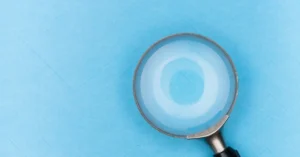 Magnifying glass on a blue background representing search intent research