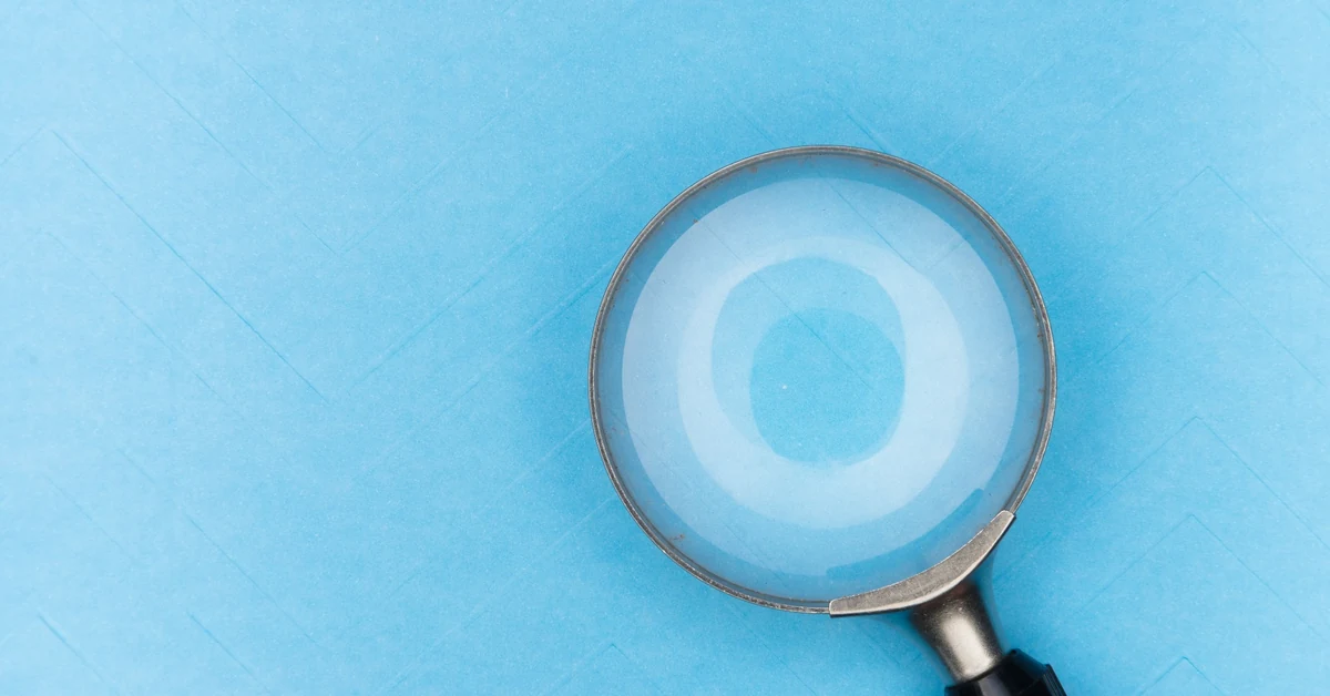 Magnifying glass on a blue background representing search intent research