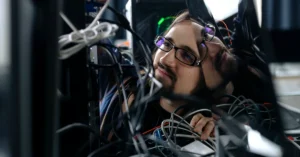 Man working through a tangle of computer cables, representing the need for an organized affiliate link management system