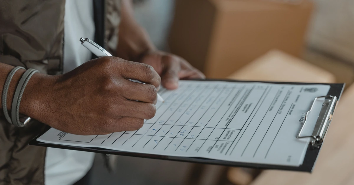 Person completing a form on a clipboard, illustrating how an affiliate opt-in form should ask only for information that serves a clear purpose.