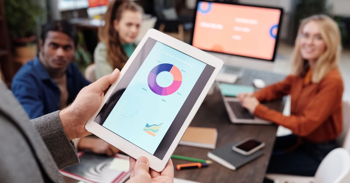 Marketing team reviewing digital traffic and campaign performance data on a tablet.