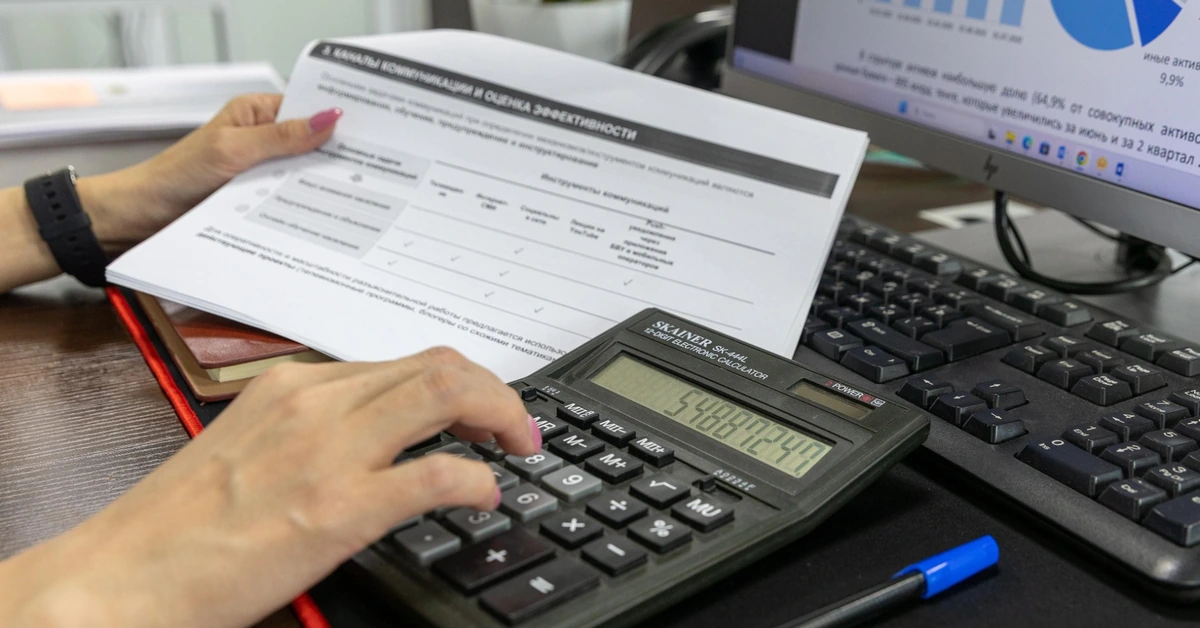 Person reviewing financial documents with a calculator, illustrating the importance of understanding affiliate program commissions and payment terms.