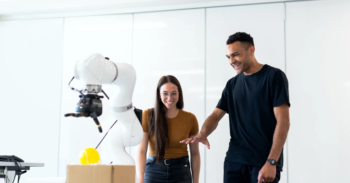 Two engineers testing a robotic prototype, illustrating the importance of testing an affiliate program before scaling promotion.