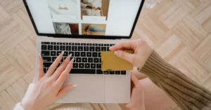 Customer reviewing an online purchase on a laptop while holding a credit card