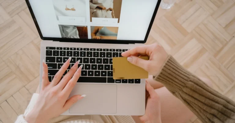 Customer reviewing an online purchase on a laptop while holding a credit card