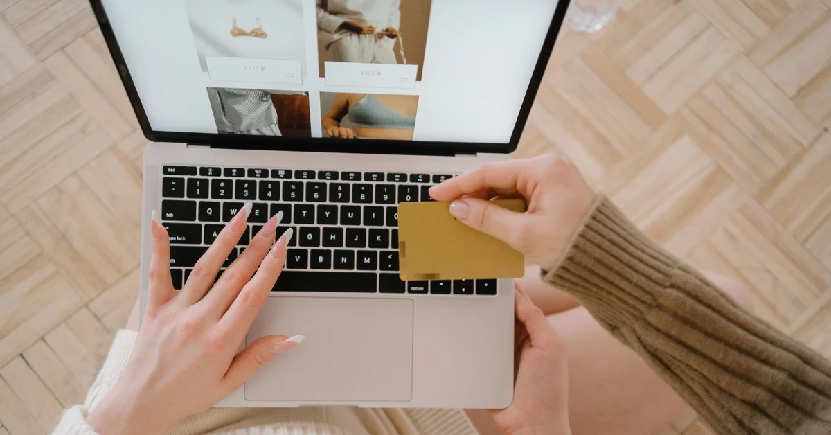 Customer reviewing an online purchase on a laptop while holding a credit card