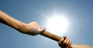 Two people passing a relay baton, representing a smooth handoff from one email to the next in a welcome sequence