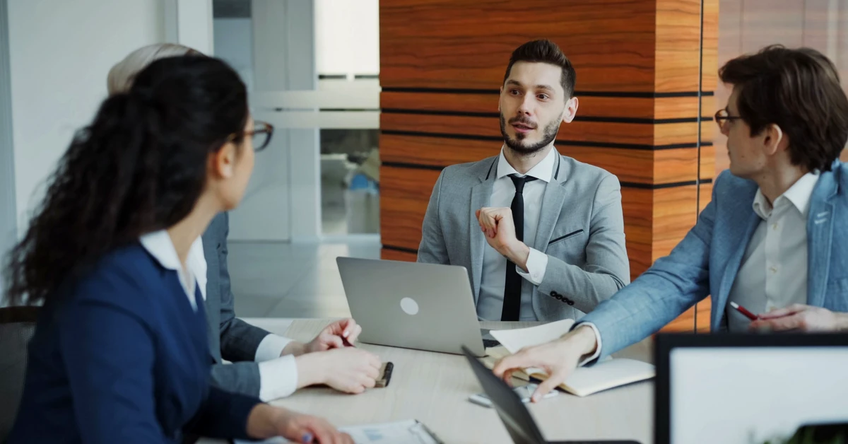Diverse business team discussing a laptop while evaluating whether an affiliate joint venture opportunity is a good fit