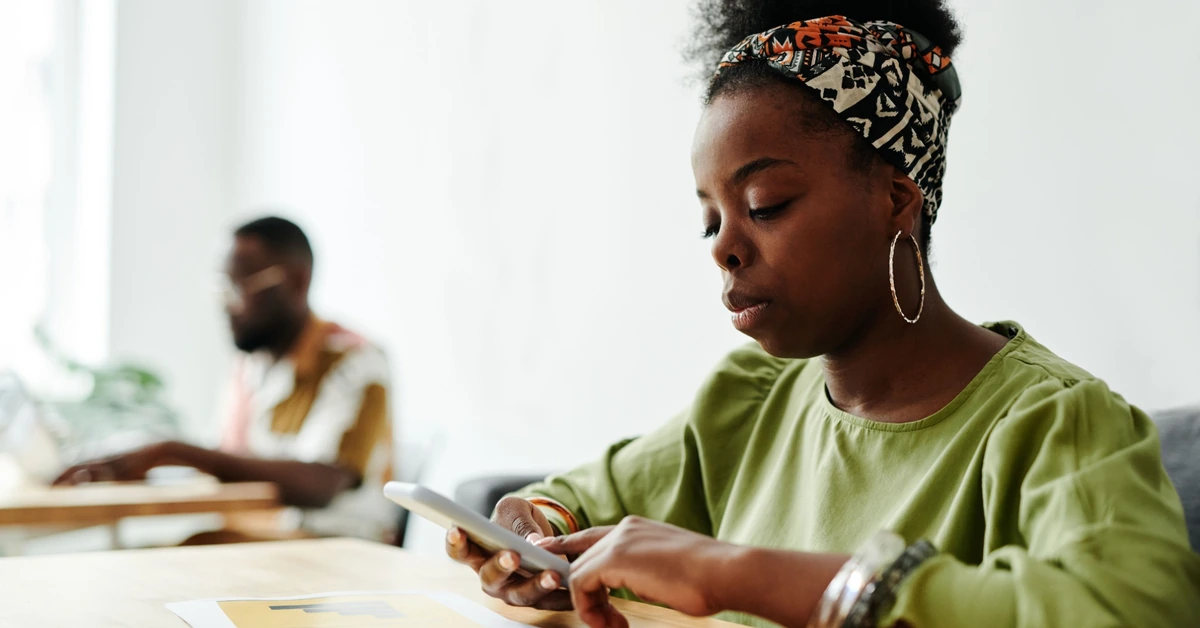 Woman using a smartphone, representing a subscriber reading and engaging with a follow-up email.