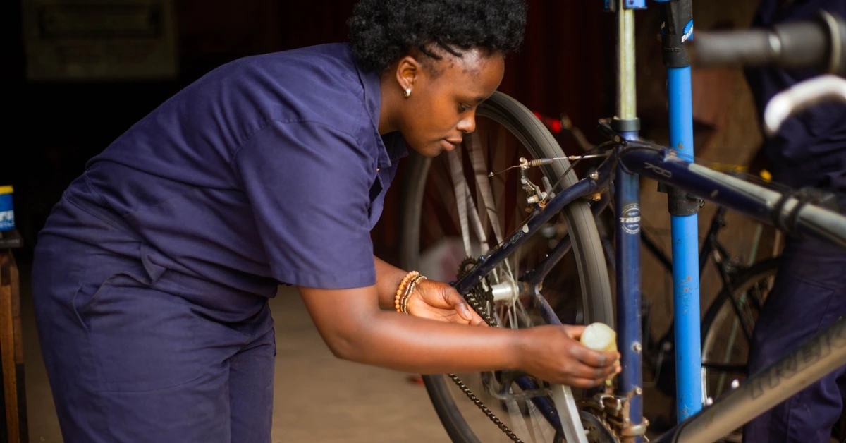 Female bicycle mechanic making a hands-on repair in a workshop, illustrating how affiliate marketing training becomes valuable when it is put into practice.