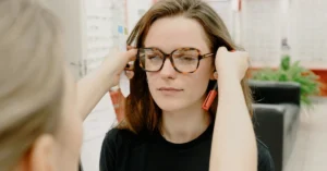Optician fitting eyeglasses on a customer, illustrating the importance of deciding whether the ClickBank Profit Club is the right fit for your affiliate marketing goals.
