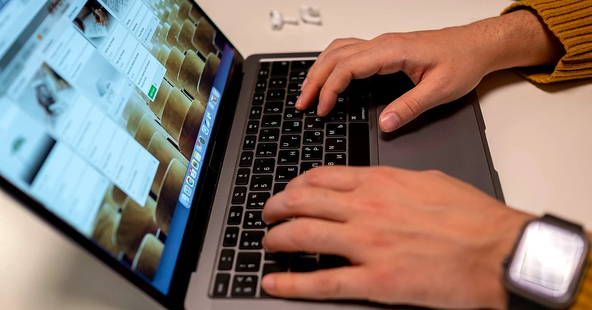 Hands typing on a laptop keyboard while entering information, representing the ClickBank affiliate account setup process.