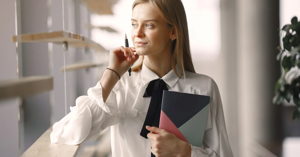 Woman holding a notebook and pen, representing turning affiliate marketing training into focused action.