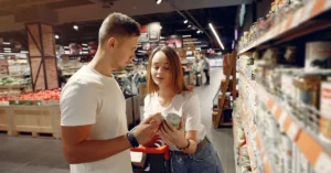 Two shoppers comparing products in a supermarket aisle, illustrating how affiliates can evaluate two ClickBank offers before choosing one to promote.