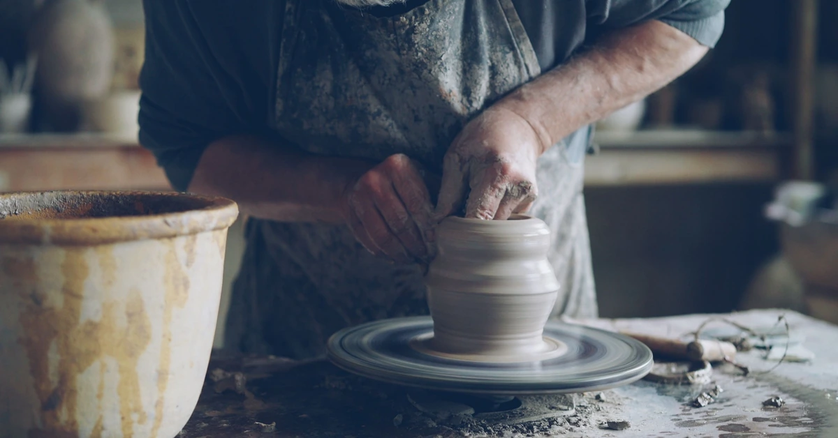 Potter carefully shaping clay on a wheel, illustrating how consistent content gradually shapes the identity of an affiliate marketing brand.