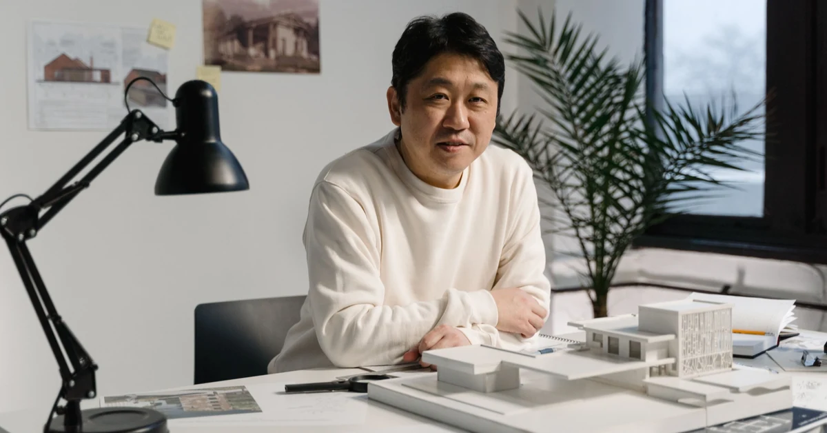 Architect reviewing a building model and plans at a desk