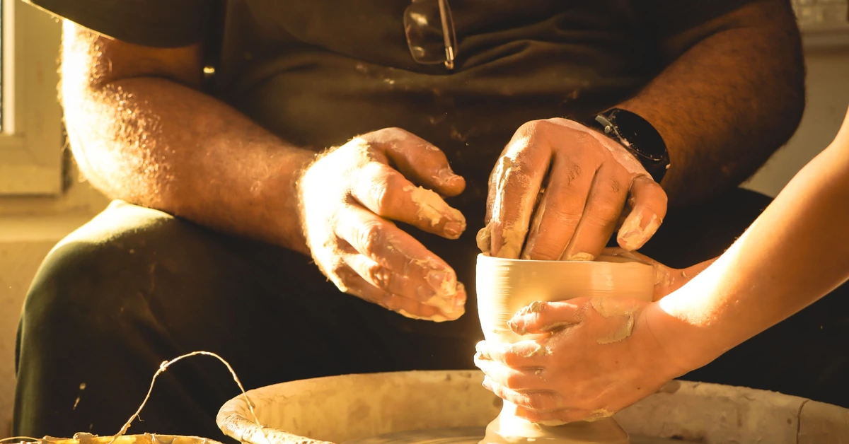 Hands shaping clay on a pottery wheel, illustrating how existing affiliate content can be refined and improved over time.