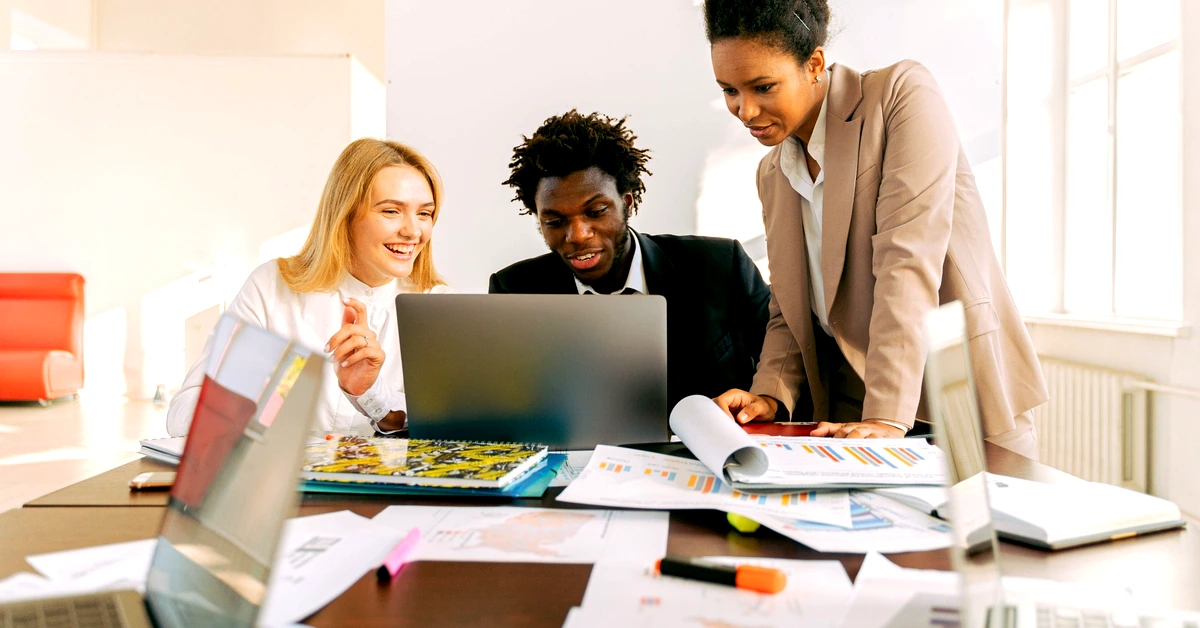 Diverse business team reviewing a laptop and performance charts while evaluating an affiliate marketing system