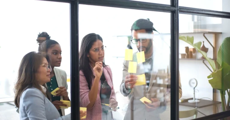 Diverse marketing team organizing sticky notes to plan a structured affiliate marketing system