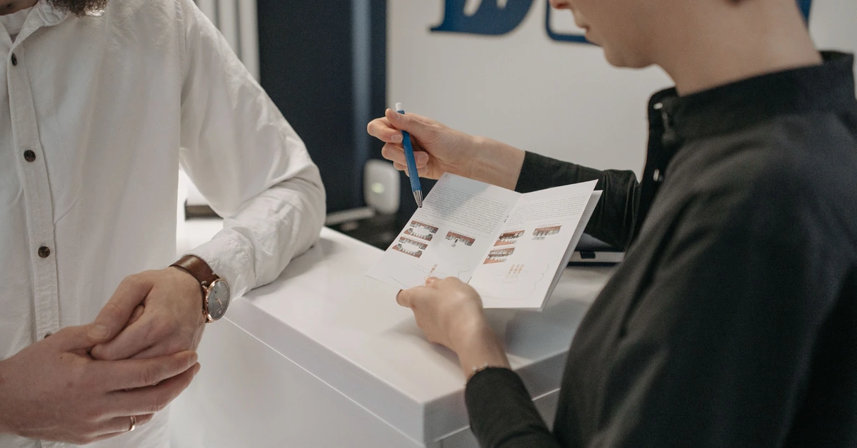 One person explaining a printed resource to another, illustrating an email opt-in that provides useful value before asking for contact information.
