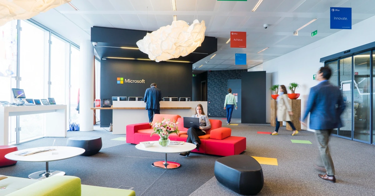 Modern office reception area with people moving through the space, illustrating how a bridge page helps guide visitors toward the next step.