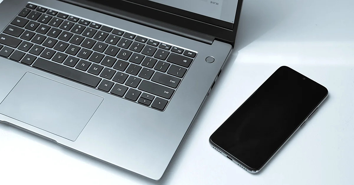 Laptop and smartphone arranged on a desk for testing landing pages across desktop and mobile devices.