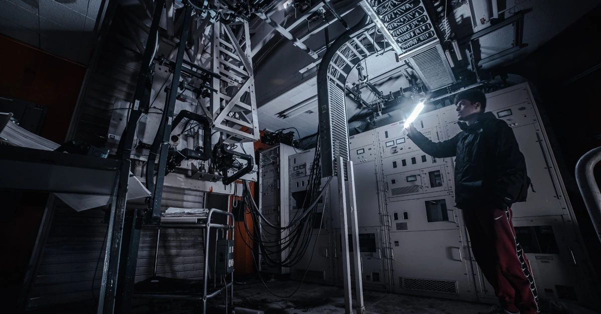 Technician inspecting complex industrial equipment, illustrating how a specialized tool works as one part of a larger system.