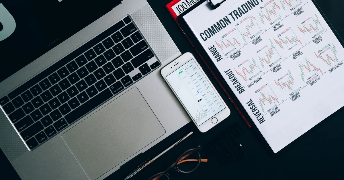Laptop, smartphone, and printed charts used to compare traffic sources for an affiliate blog.