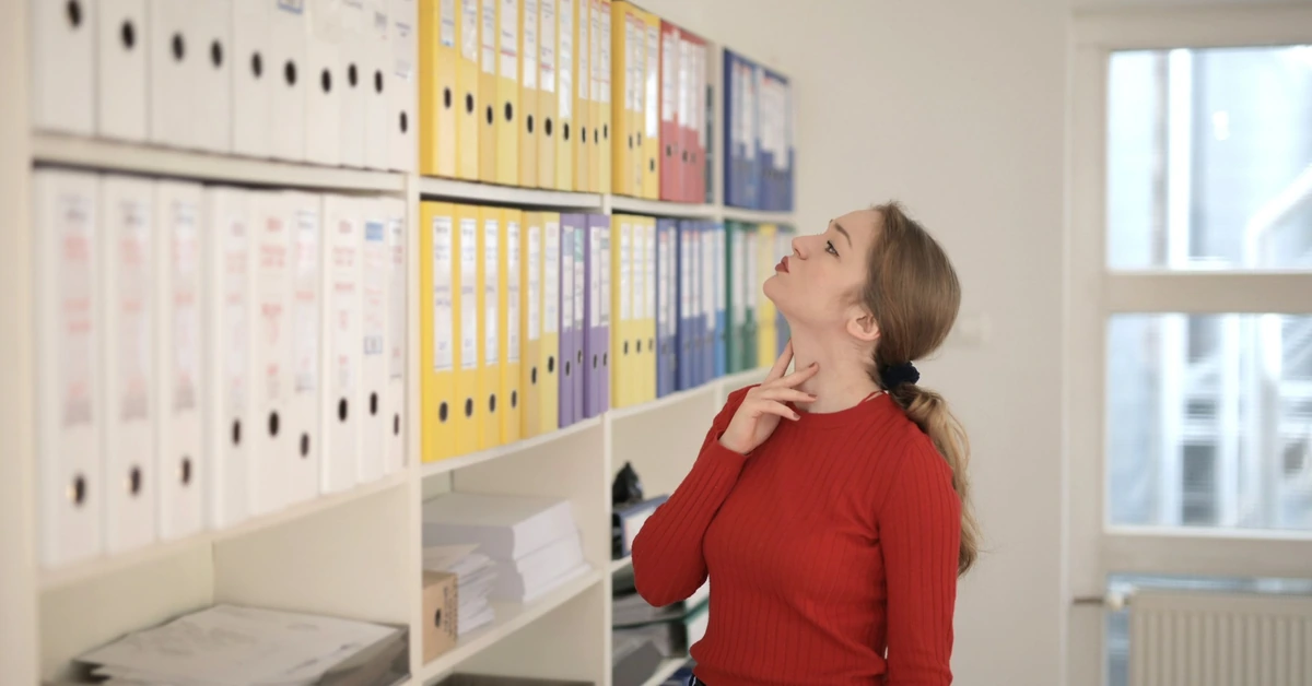 Woman choosing among folders in an office, representing focusing on one offer at a time.