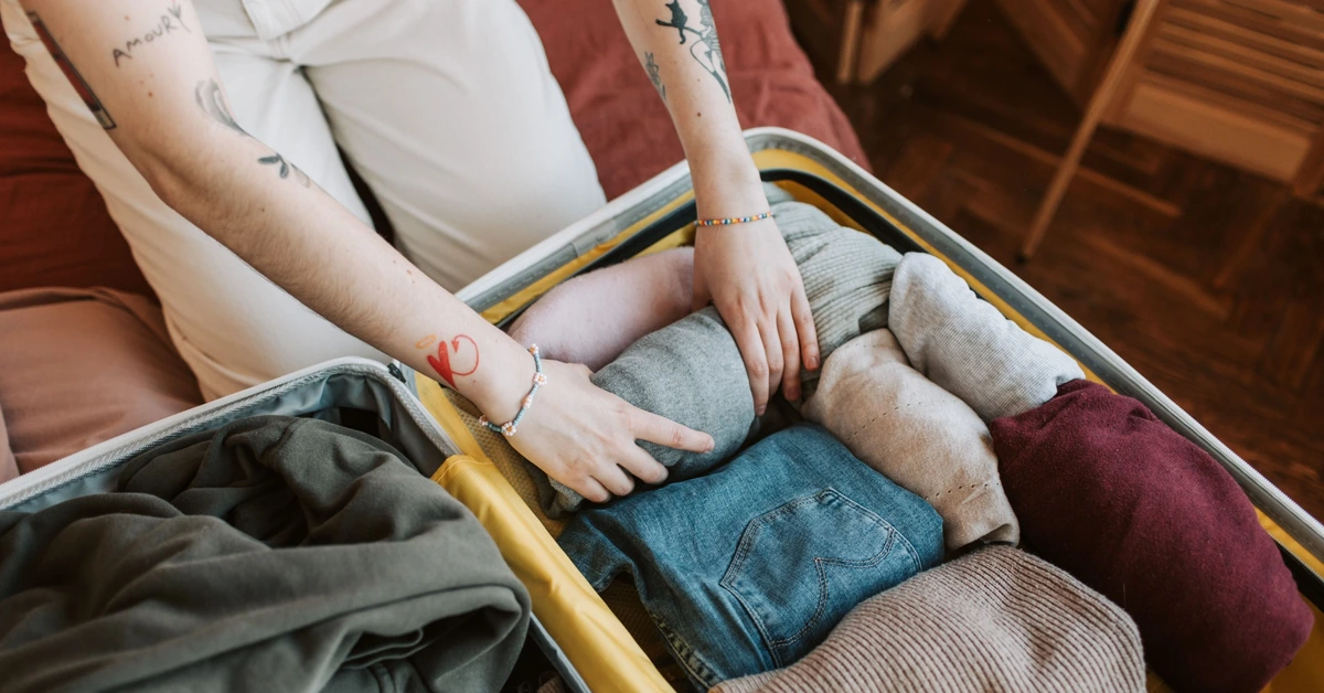 Person packing a full suitcase, illustrating how growing needs can eventually require more capacity than a free email marketing plan provides.
