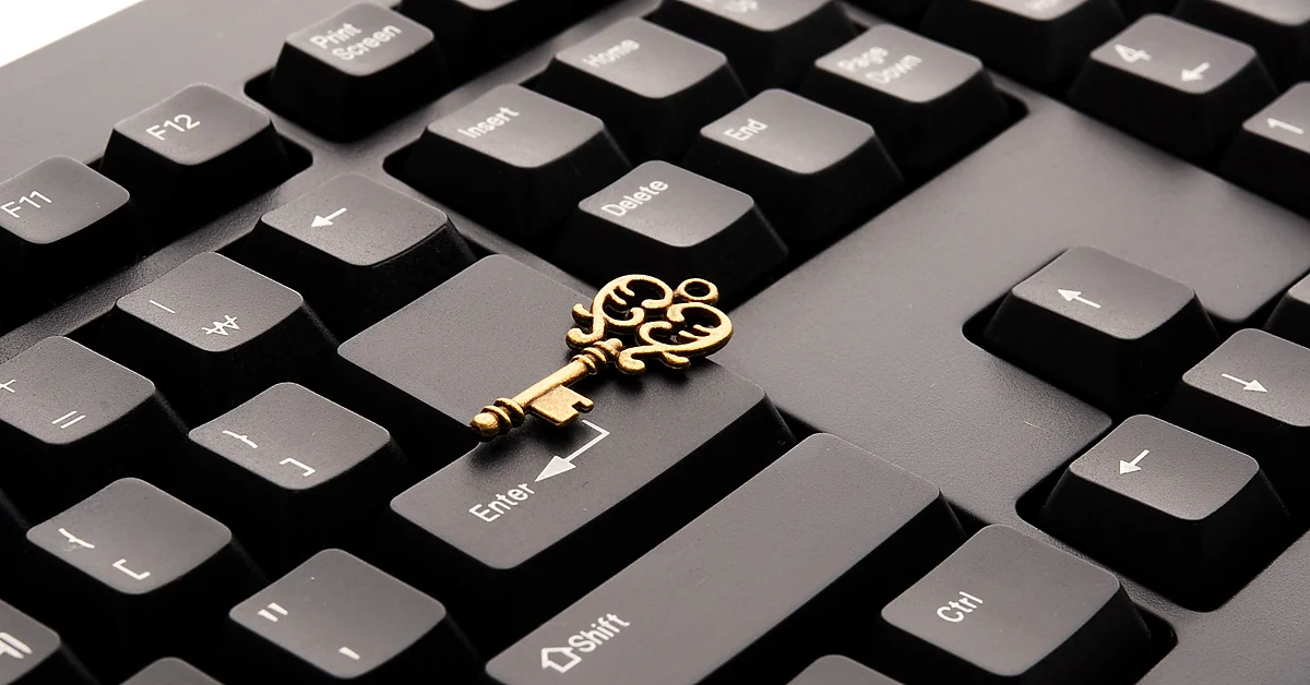 Ornate brass key resting on a black computer keyboard, symbolizing digital privacy and information protection.