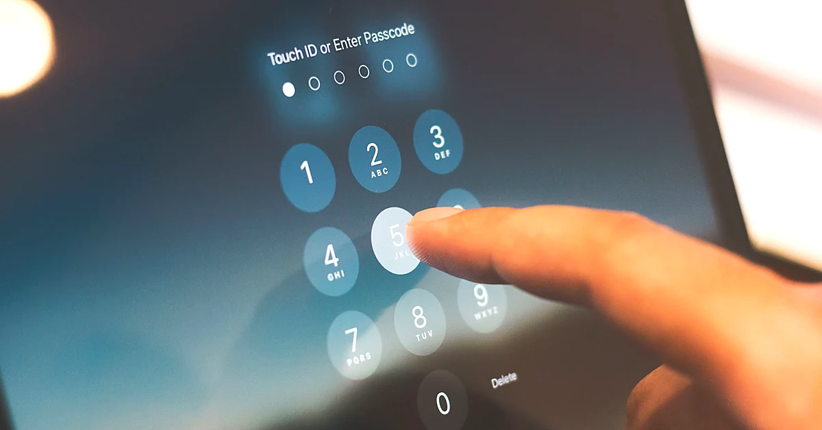 Close-up of a person's finger entering a passcode on a tablet's lock screen to illustrate secure account access.